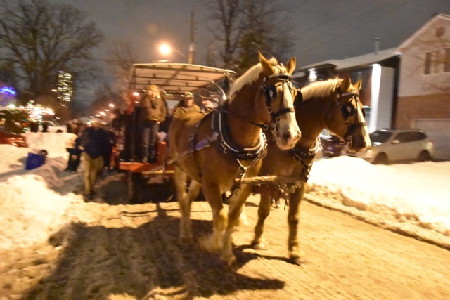 Horse-drawn sleigh full of carollers.