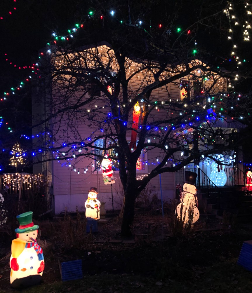 [Maison avec des guirlandes lumineuses partout et des hordes de bonhommes de neige lumineux sur le sol]